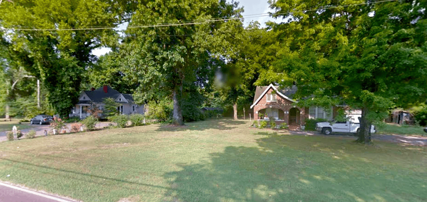 Lush green trees and historic houses in Memphis Tennessee, showcasing local heritage and architecture.
