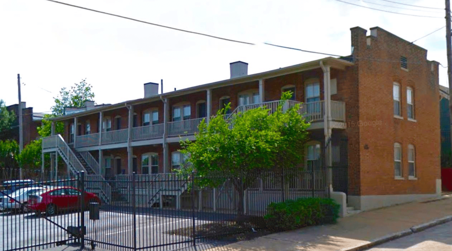Modern brick apartment building with a balcony and trees, part of Memphis Heritage Inc. property preservation efforts in Memphis, Tennessee. Focused on historic preservation, community development, and revitalization.