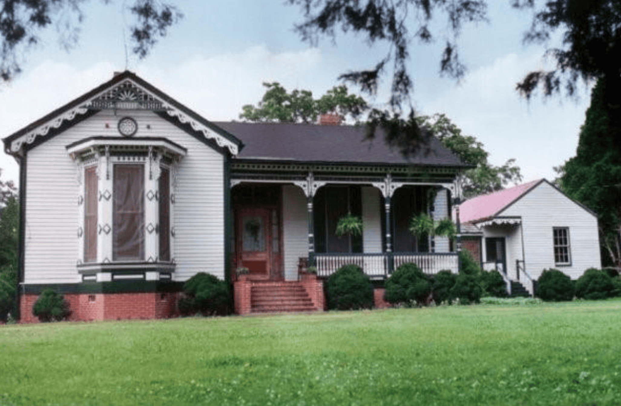 Vintage Victorian-style house with ornate trim and lush front lawn, representing Memphis Heritage Inc.'s dedication to preserving historic architecture in Memphis.